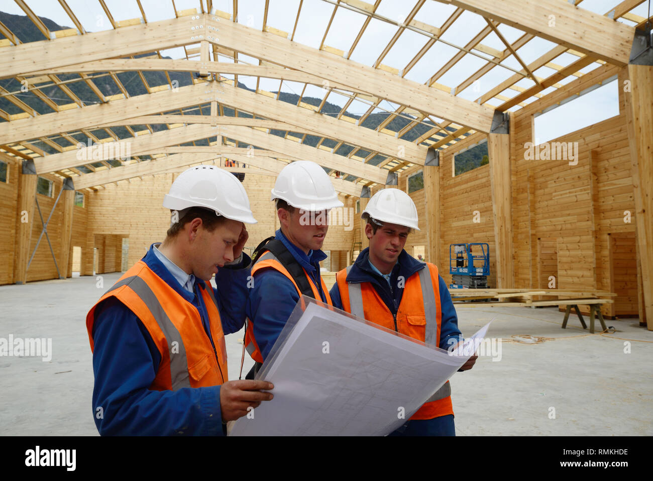 Three builders discuss the plan for a major construction job Stock Photo
