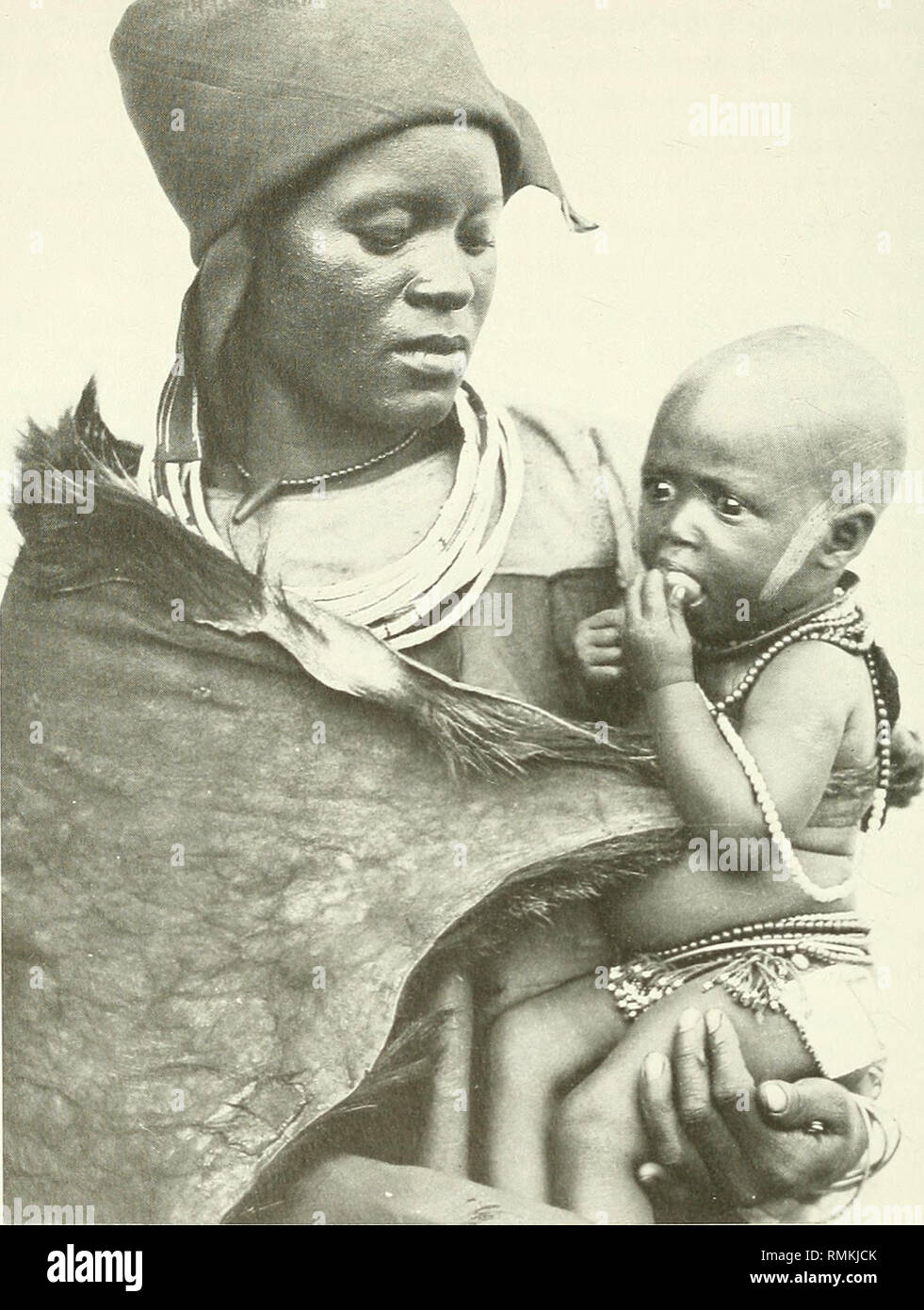 . Annals of the South African Museum = Annale van die Suid-Afrikaanse Museum. Natural history. 328 ANNALS OF THE SOUTH AFRICAN MUSEUM. Fig. 6. Hlubi woman holding her child. The skin imbeleko around her shoulders is used for carrying the baby on her back, c. 1930. (Duggan-Cronin collection, McGregor Museum.). Please note that these images are extracted from scanned page images that may have been digitally enhanced for readability - coloration and appearance of these illustrations may not perfectly resemble the original work.. South African Museum. Cape Town : The Museum Stock Photo