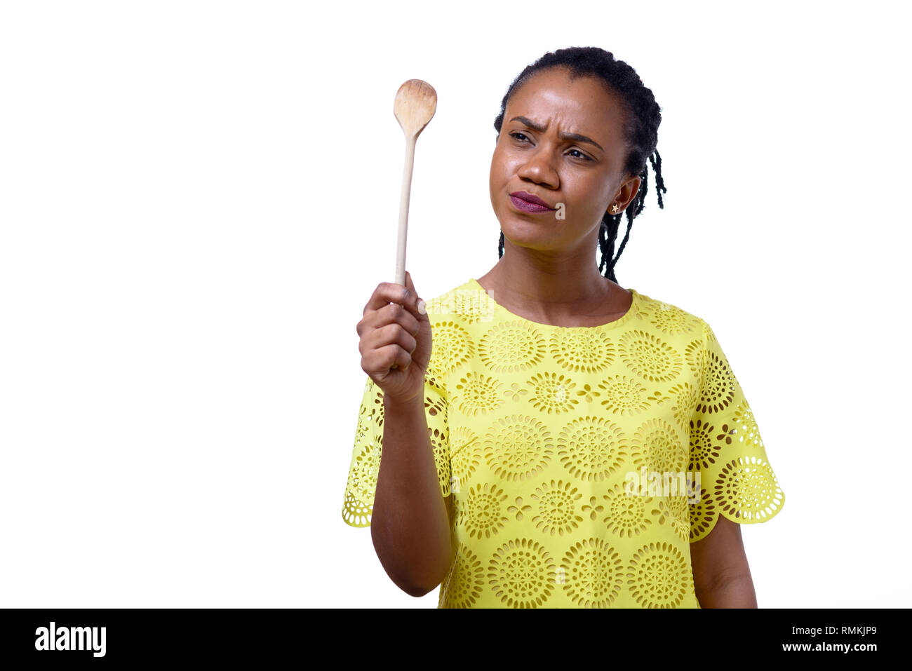 Displeased African American woman holding dirty wooden spoon against white  background Stock Photo - Alamy