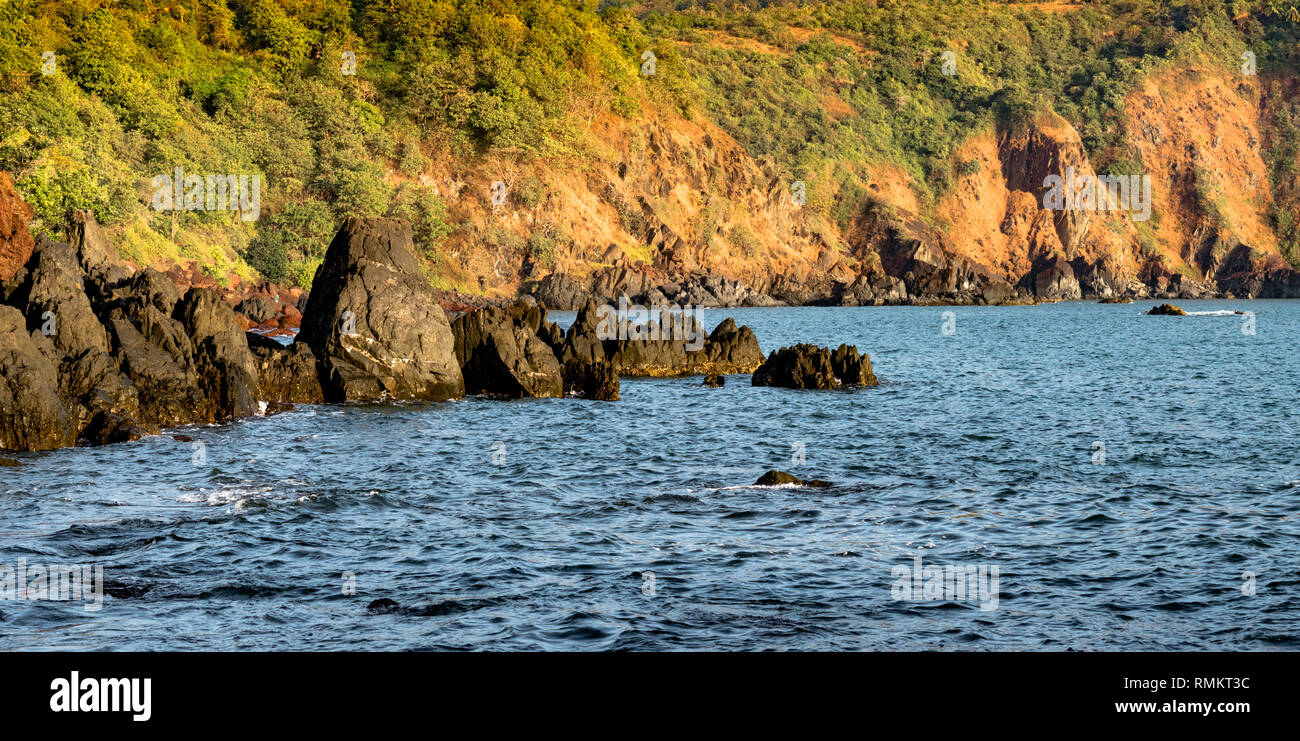 Beautiful Landscape from a remote island showing the typical geoglogy of Western Ghats of India with blue sea water and mountains along the coastline. Stock Photo