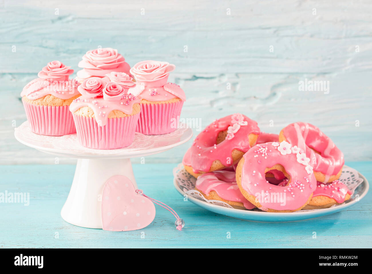 Pink donuts and cup cakes on a blue background Stock Photo