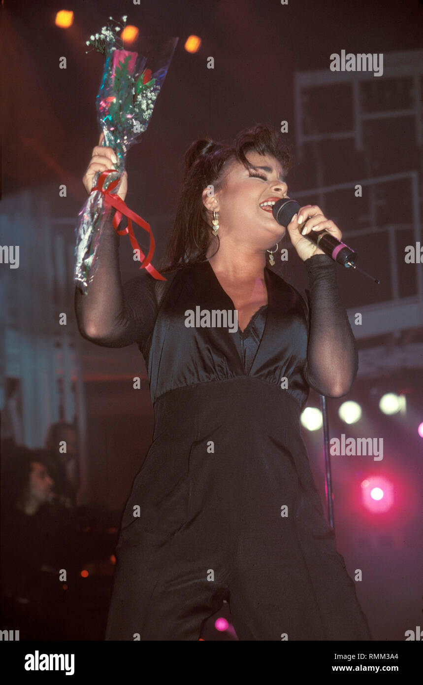 Paul Abdul is shown performing in concert while holding long stem red roses that were given to her by a fan during her show at the Hartford Civic Center in Hartford, Connecticut. Stock Photo