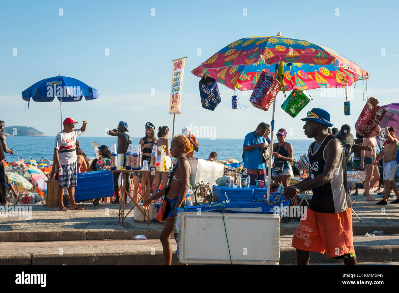 RIO DE JANEIRO - FEBRUARY 28, 2017: Unlicensed Brazilian vendors serve drinks and snacks to crowds celebrating at a Carnival street party in Ipanema. Stock Photo