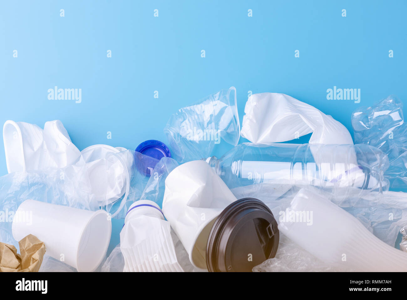 Used unsorted clean garbage in a pile. Bottles, bags and paper on blue background. Concept of environmental pollution and waste sorting Stock Photo