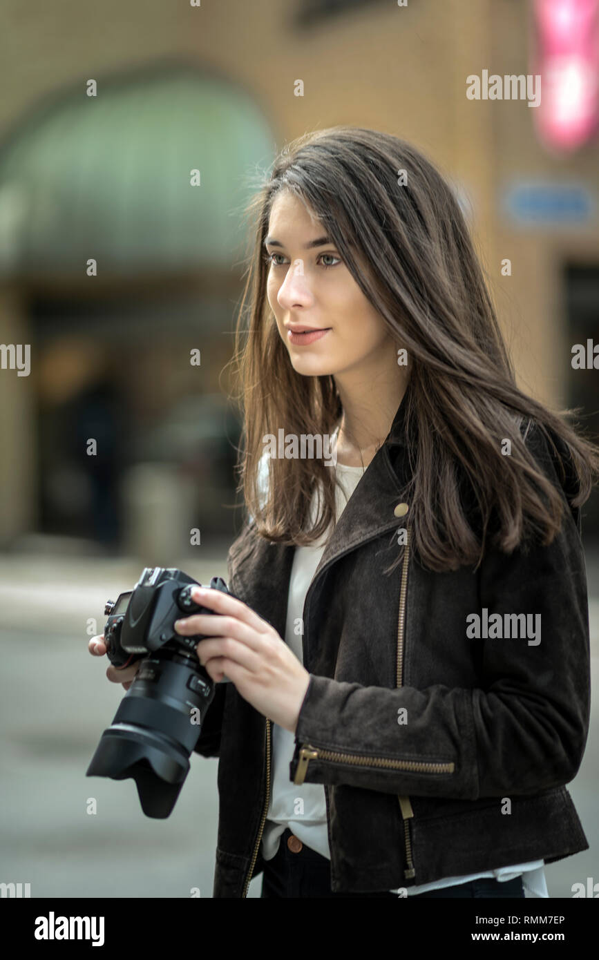 Young woman holding camera Stock Photo - Alamy