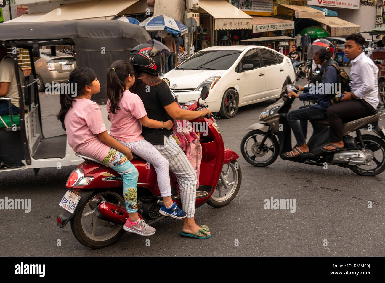 A Cambodian girl is sqeezed between a driver and a passenger of an  overloaded motorbike taxi in the capital Phnom Penh, Tuesday, April 4,  2006. Overloaded motorcycles and cars are a common