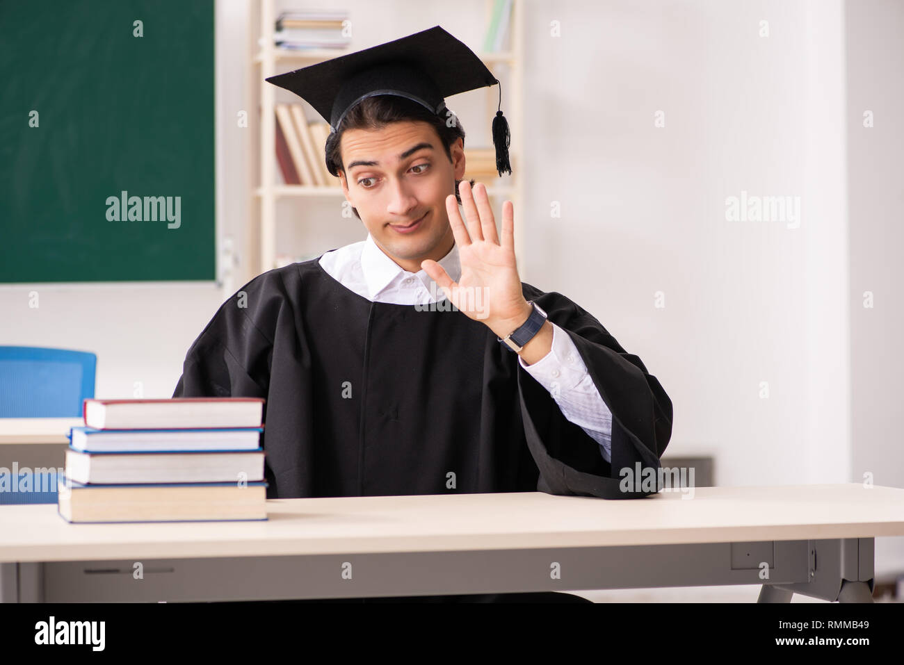 Graduate Front Use Graduate student in front of green board Stock Photo - Alamy