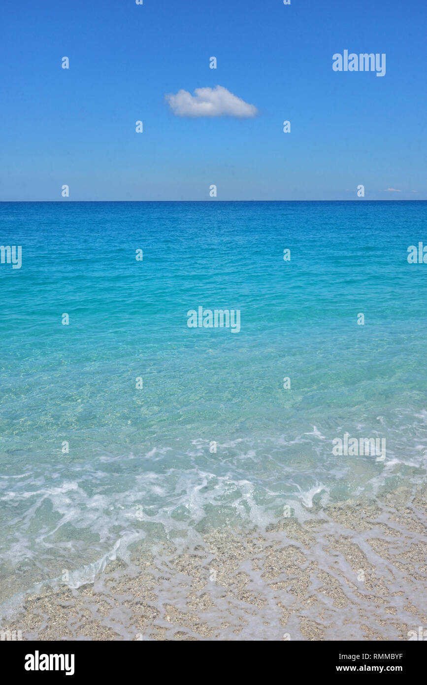 Minimalist crystal clear waters and a cloud in Greece Stock Photo