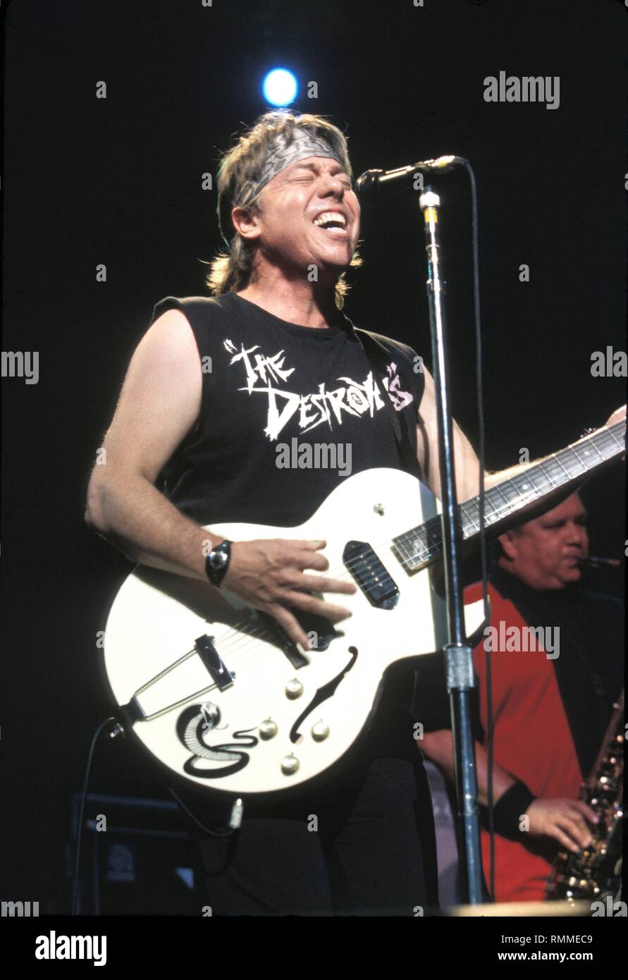 Musician Thorogood is shown performing on stage during a "live