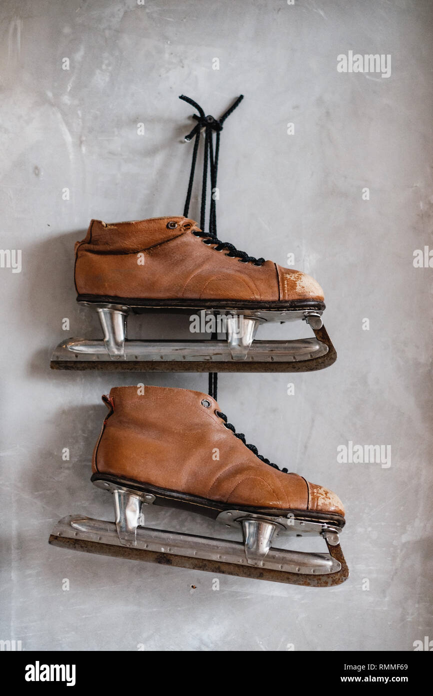 Vintage pair of men's ice skates hanging on a wall Stock Photo Alamy