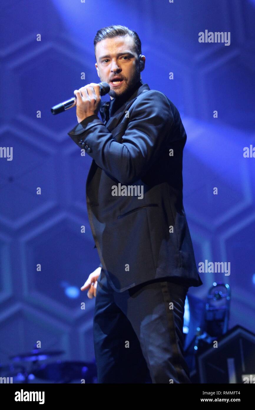 Justin Timberlake is shown singing on stage during a live concert performance. Stock Photo