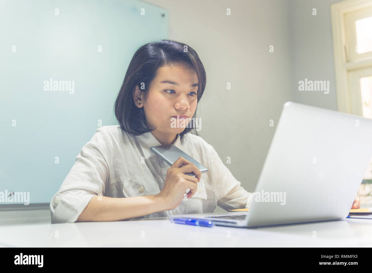 Young Asian woman thinking about the finance Stock Photo