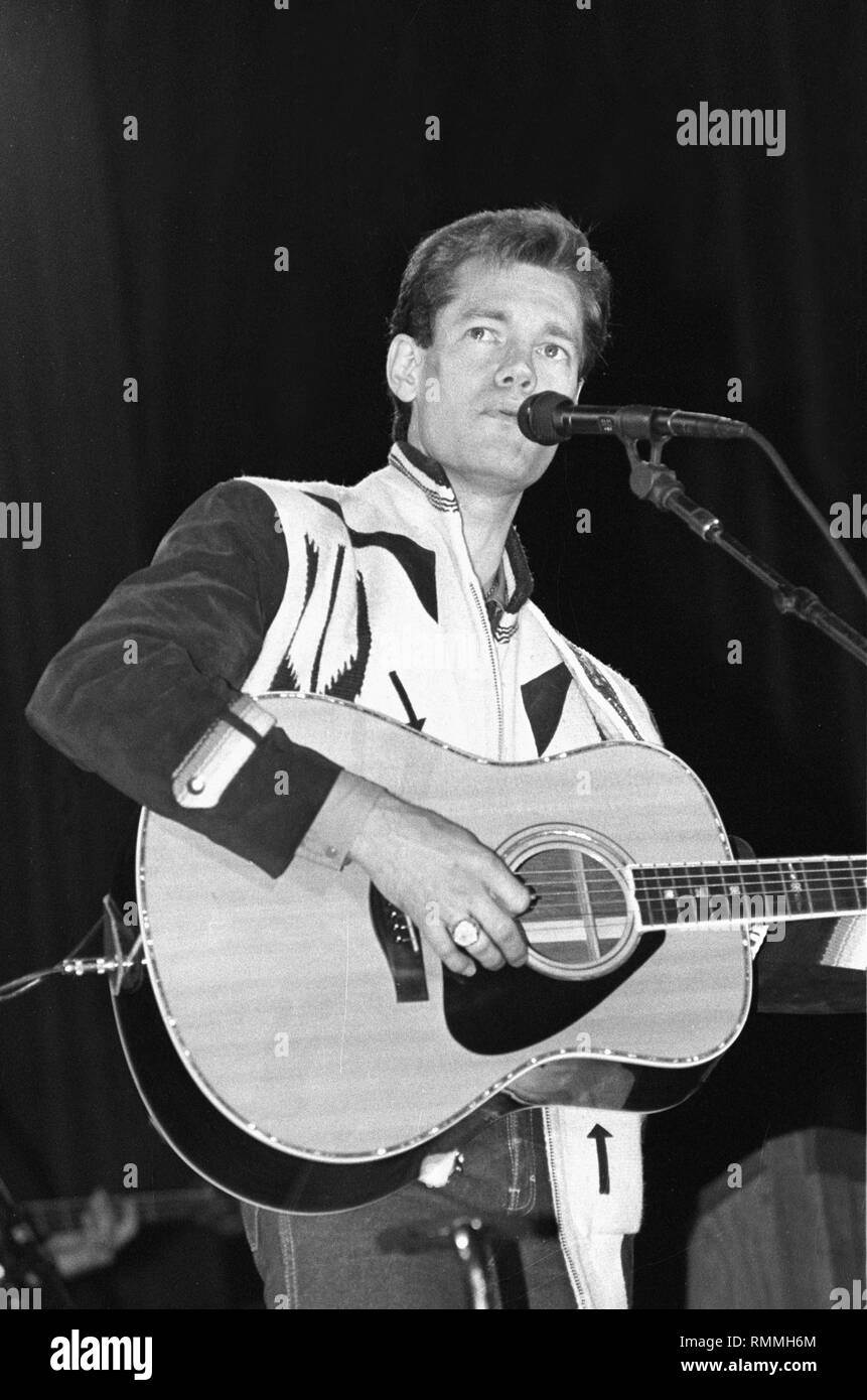 Musician Randy Travis is shown performing on stage during a "live