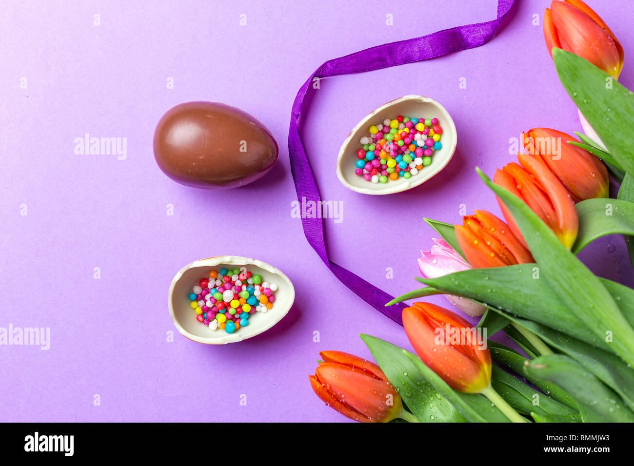 Easter composition with chocolate eggs and tulips,  space for text , top view Stock Photo