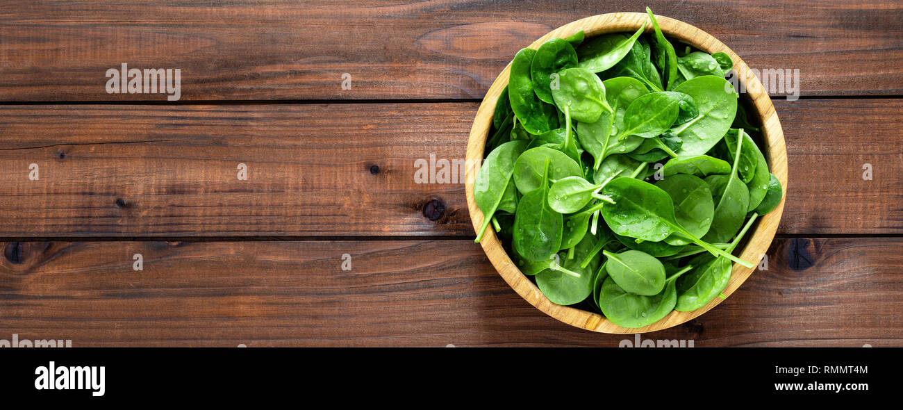 Fresh spinach leaves on wooden background. Healthy vegan food. Top view ...