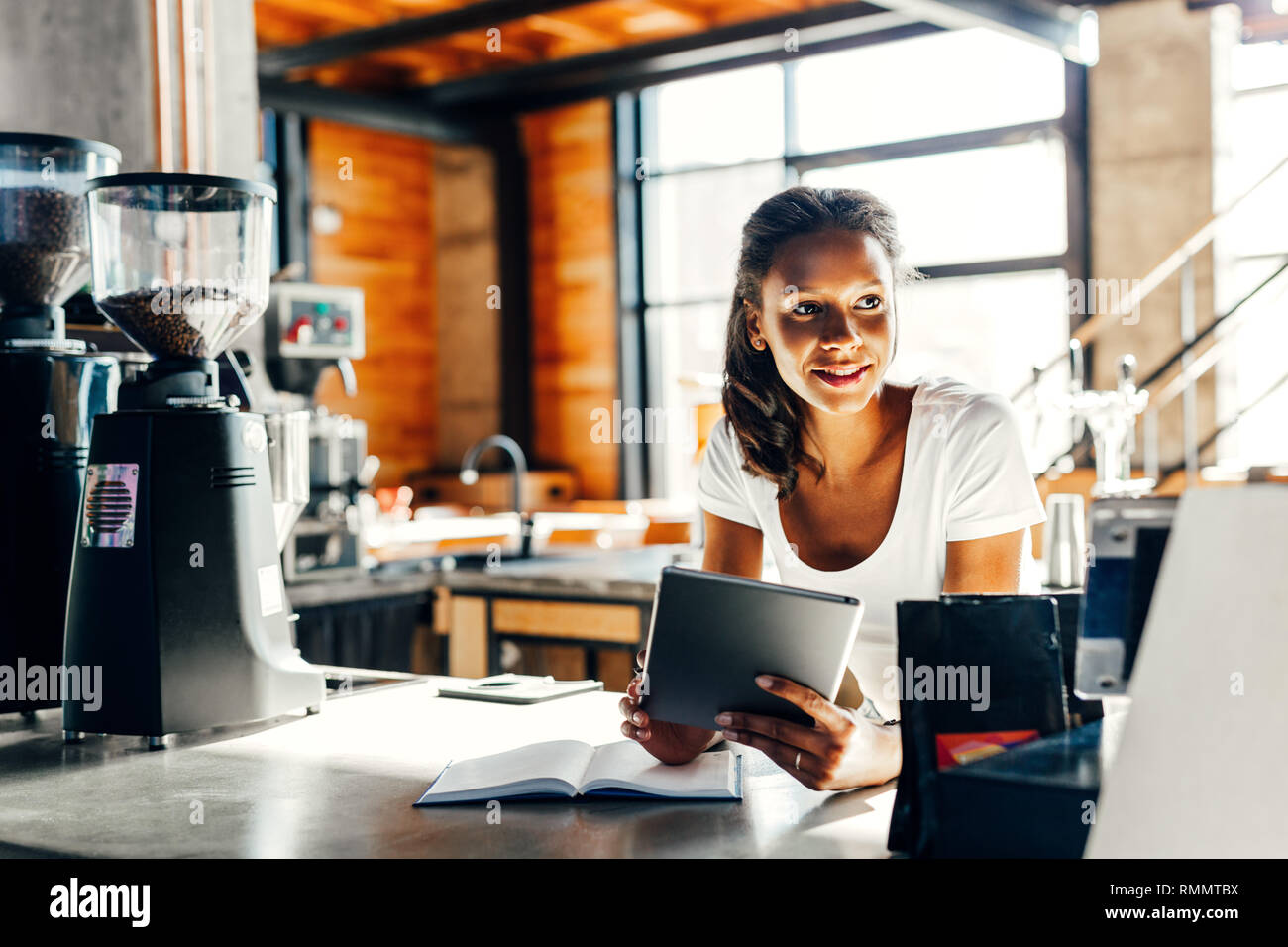 Cafe owner using digital tablet at counter Stock Photo
