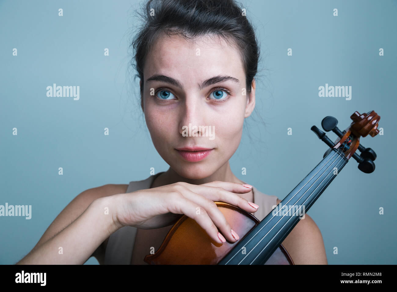 Close up portrait of a beautiful young woman posing with a violin ...