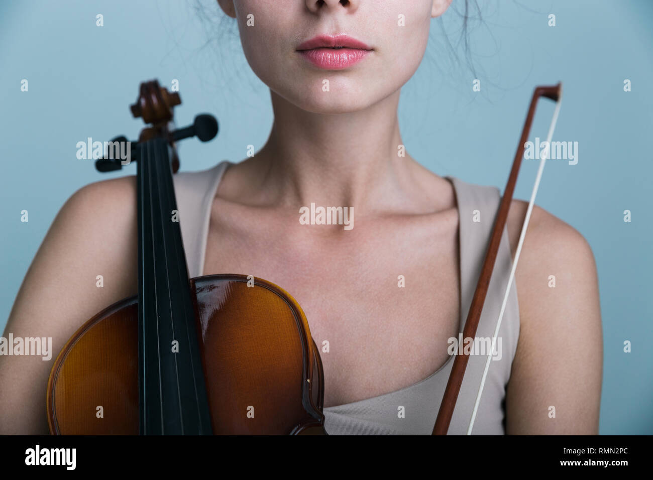 Cropped image of a beautiful young woman posing with a violin isolated ...