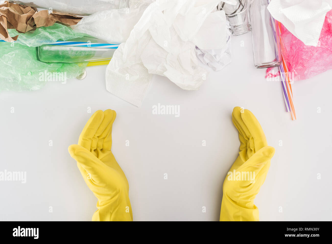 Partial view of man in yellow rubber gloves among glass bottles ...