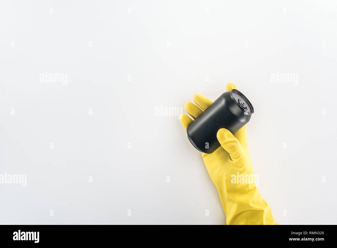 Cropped view of man in yellow rubber gloves holding empty black can on ...