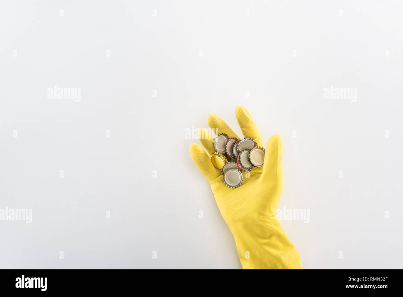 Cropped view of man in yellow rubber gloves holding bottle caps Stock ...