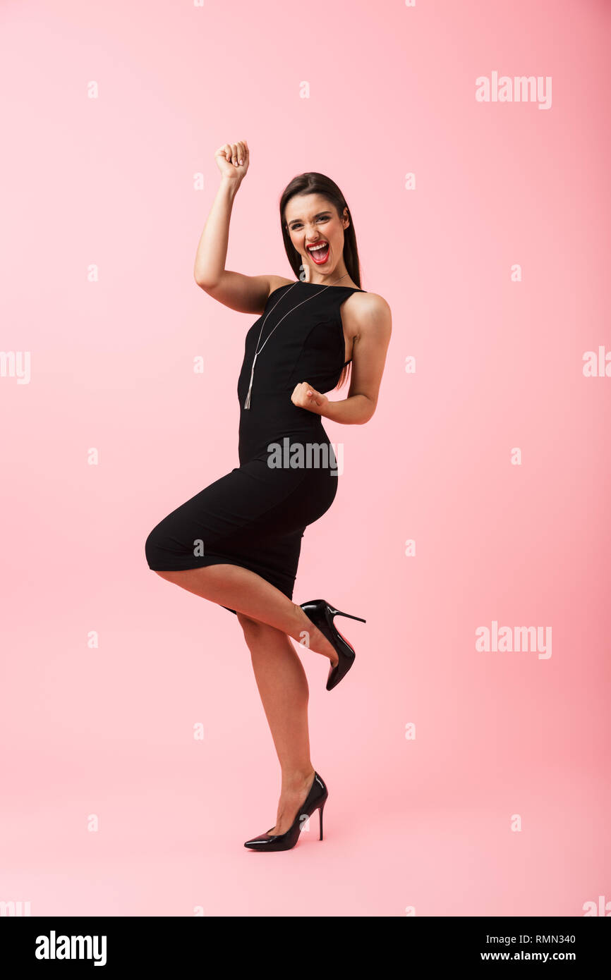 Full length portrait of a beautiful young woman wearing black dress ...