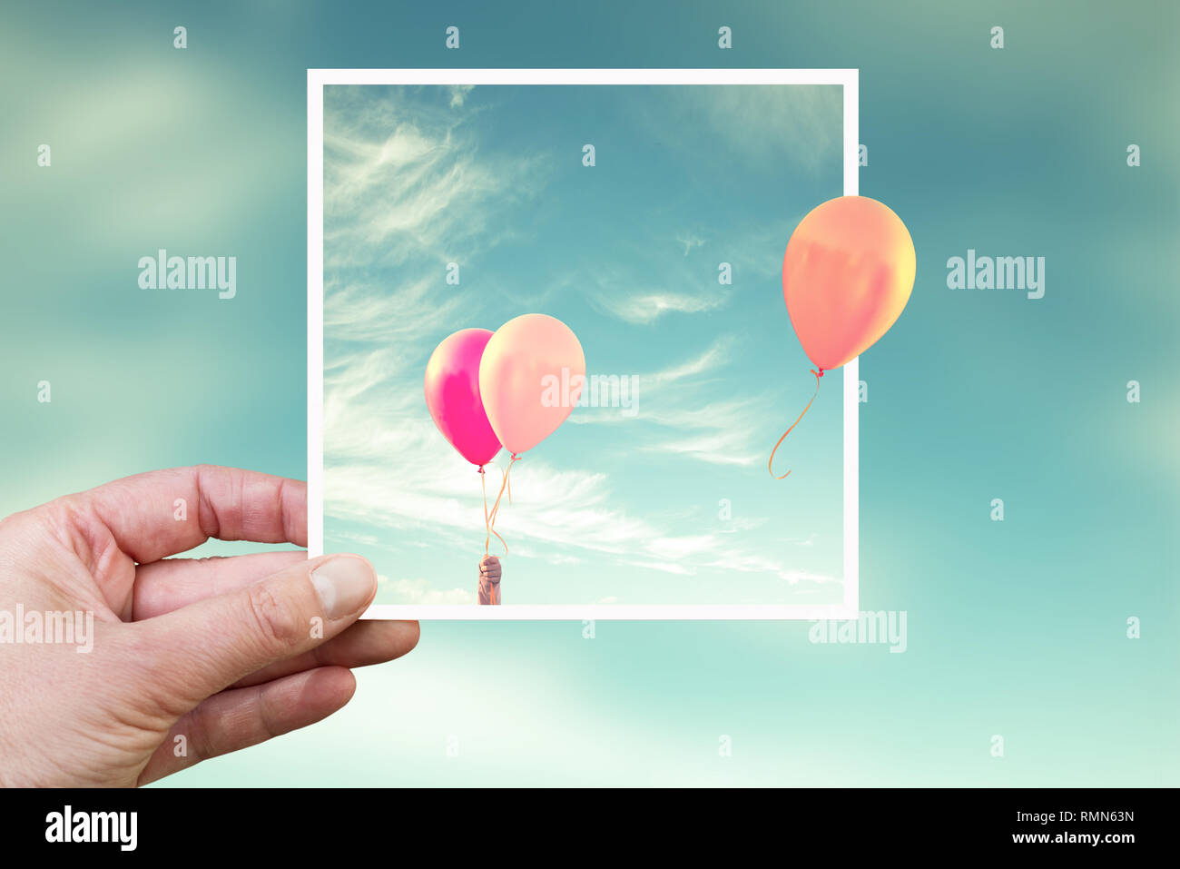 Hand holding an instant photo with air balloons, think outside the box concept Stock Photo