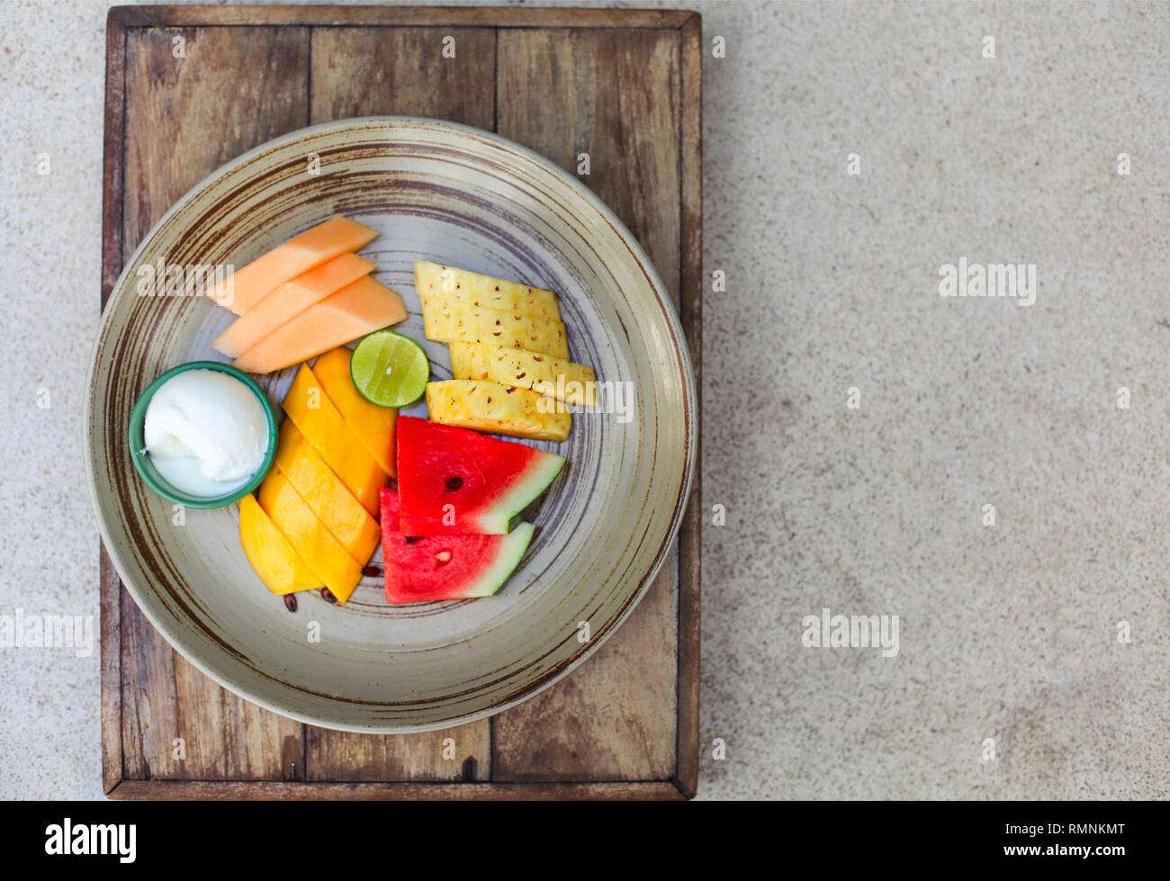 Colorful summer fruit platter with watermelon, mango, pineapple, lime