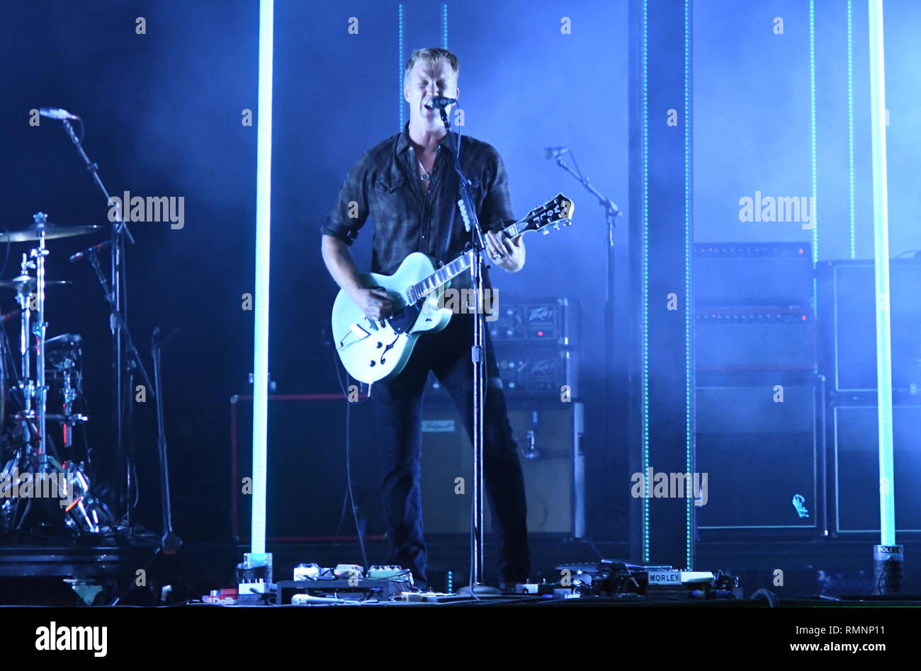 Musician Josh Homme and Queens of the Stone Age are shown performing on stage during a 'live' concert appearance. Stock Photo