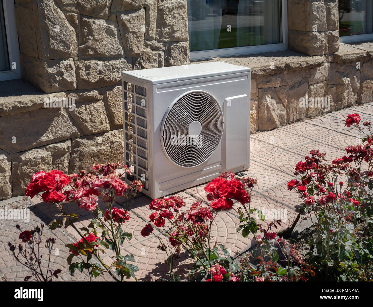 High efficiency modern AC-heater inverter unit, energy save solution-horizontal, outside a residential home Stock Photo