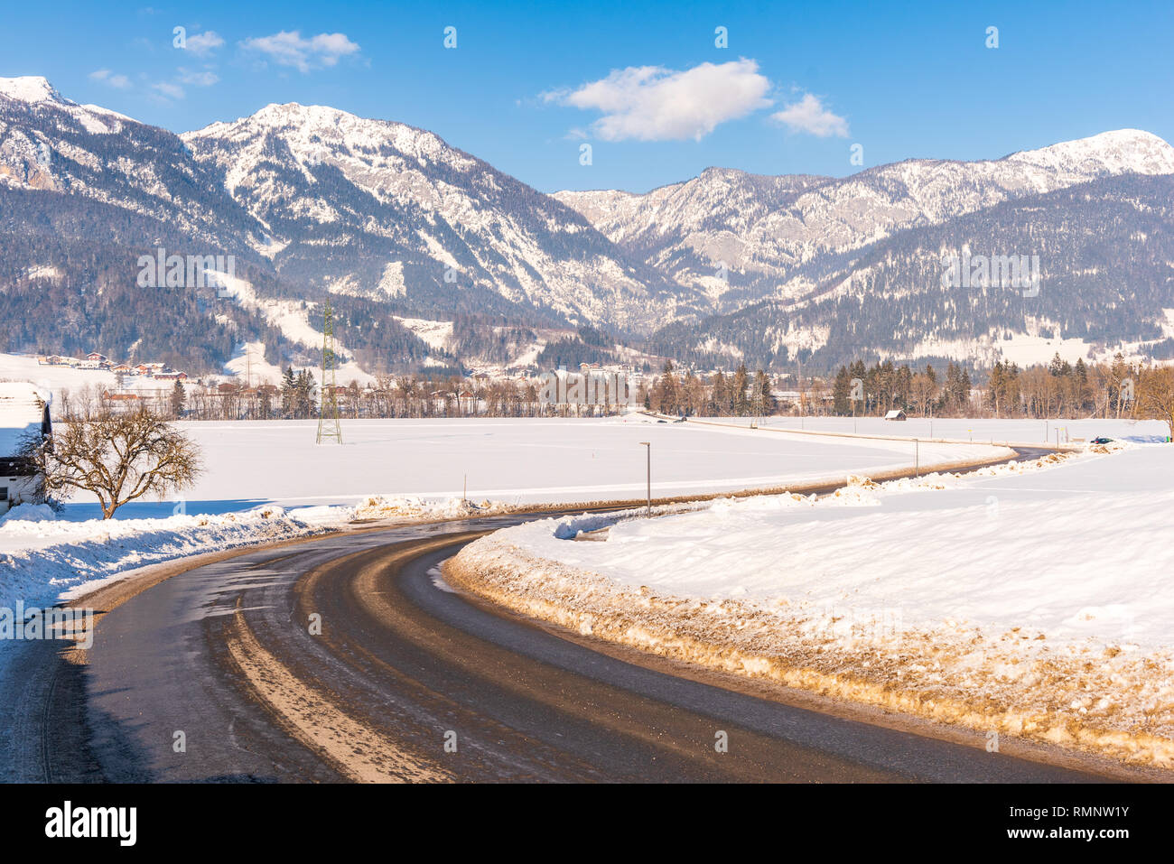 Empty, snow-covered, winter road to Weißenbach with mountains in the background, Dachstein massif, Liezen District, Styria, Austria, Europe Stock Photo