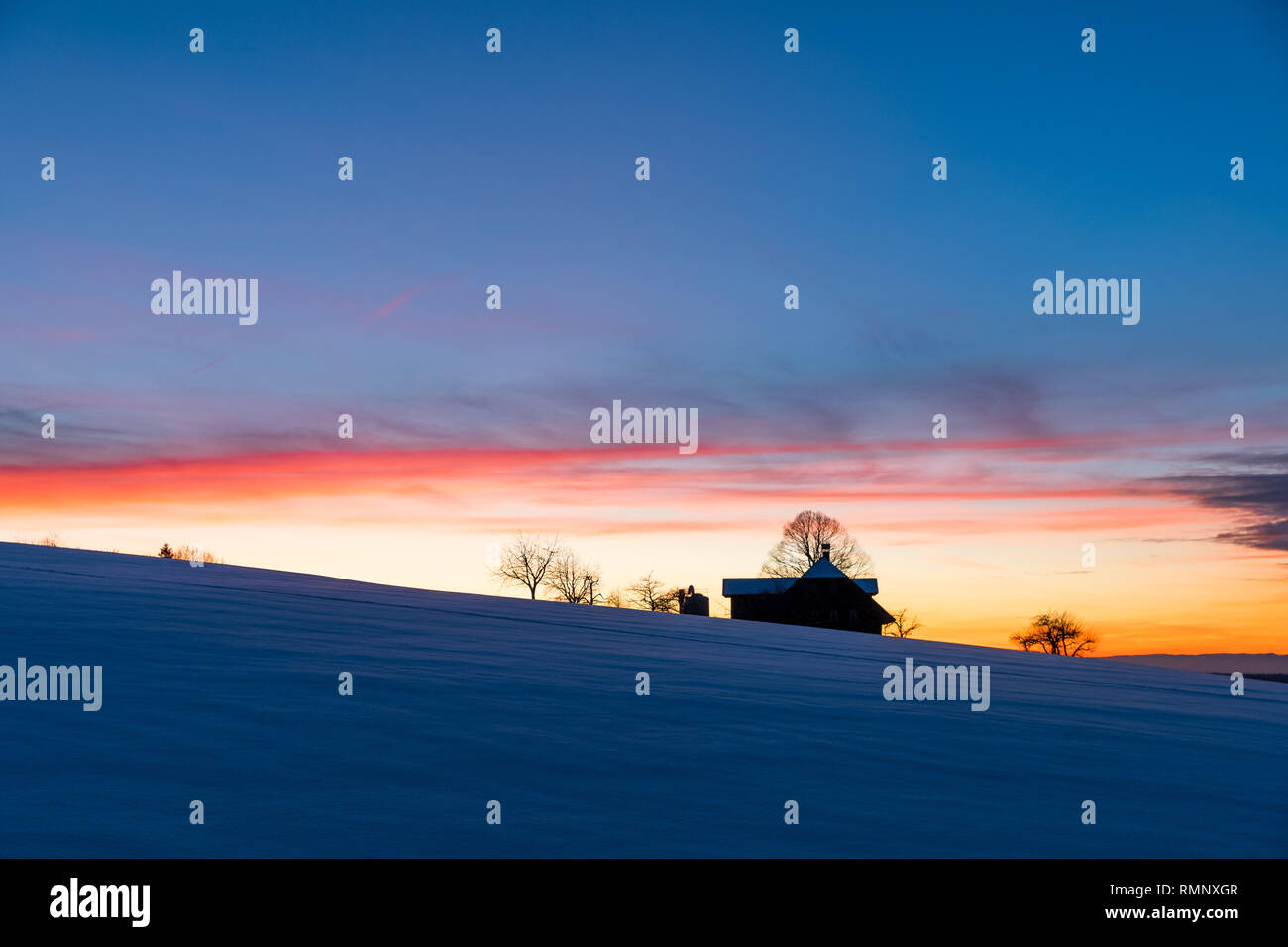 silhouette of a farm in Emmental at a winter sunset Stock Photo