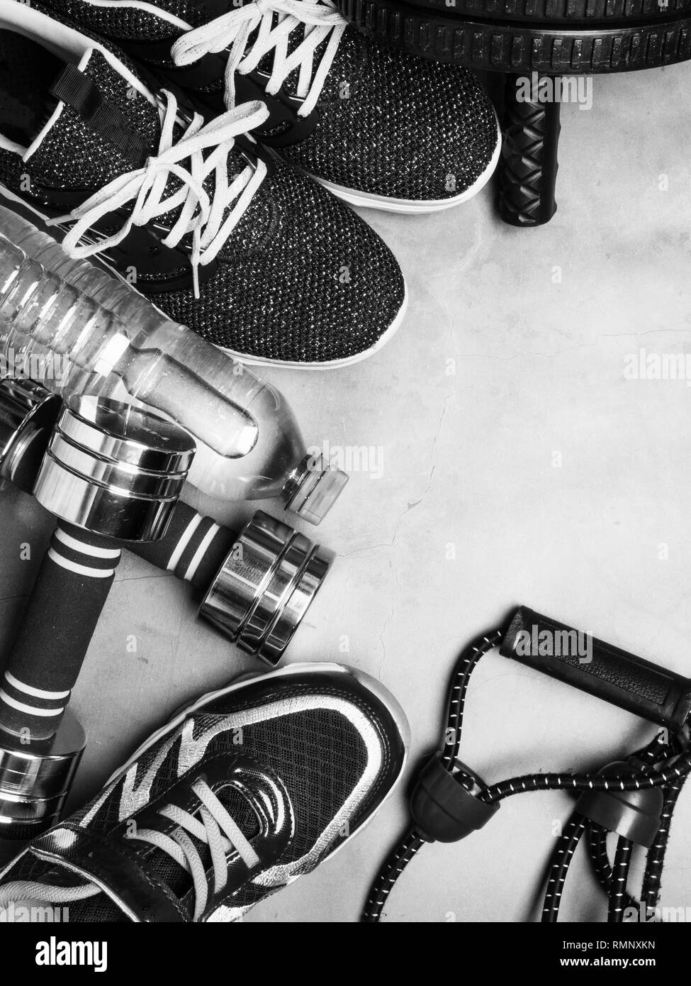 Top view image of sport shoes, dumbbells, press roll, water, expander. Fitness or workout equipment. Weight loss and sports concept with copy space Stock Photo