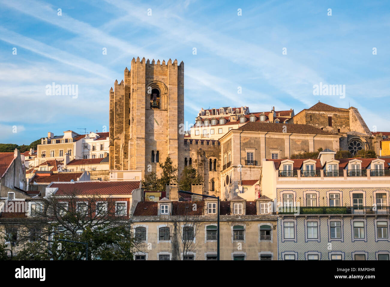Street view of Alfama neighbourhood in Lisbon Portugal with the Sé cathedral rising up above neighboring apartment buildings Stock Photo