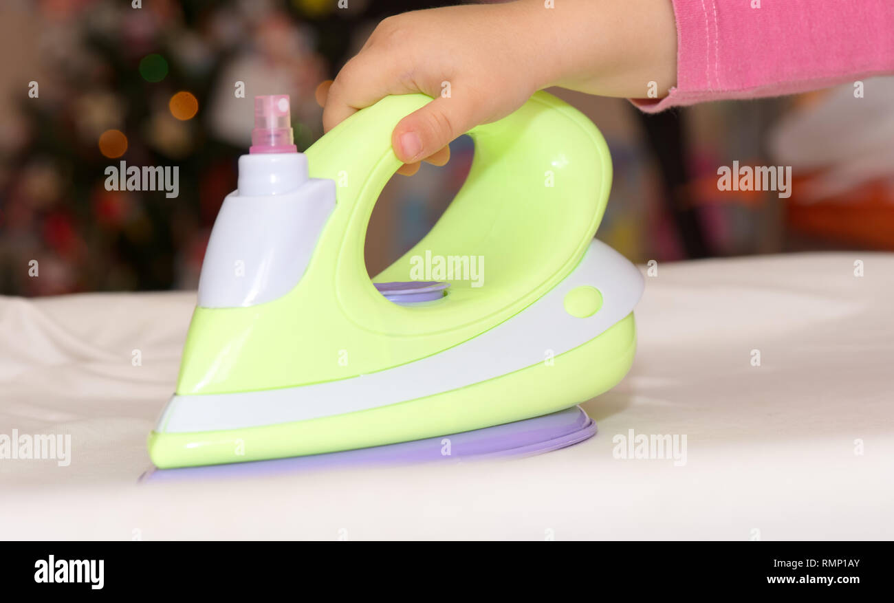 Child's hand holding a plastic toy iron Stock Photo Alamy