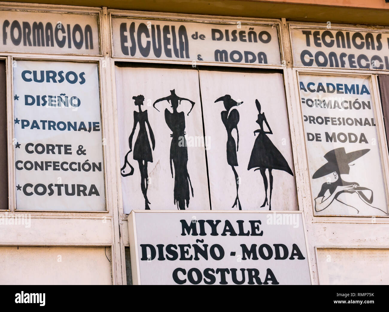 Old fashioned 1950s style female figure fashion drawings on shopfront, Malaga, Andalusia, Spain Stock Photo