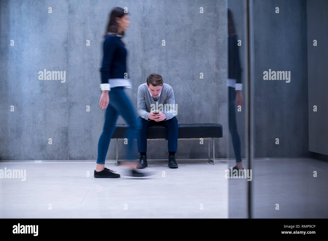Young Businessman Using Smart Phone While Sitting On The Bench At
