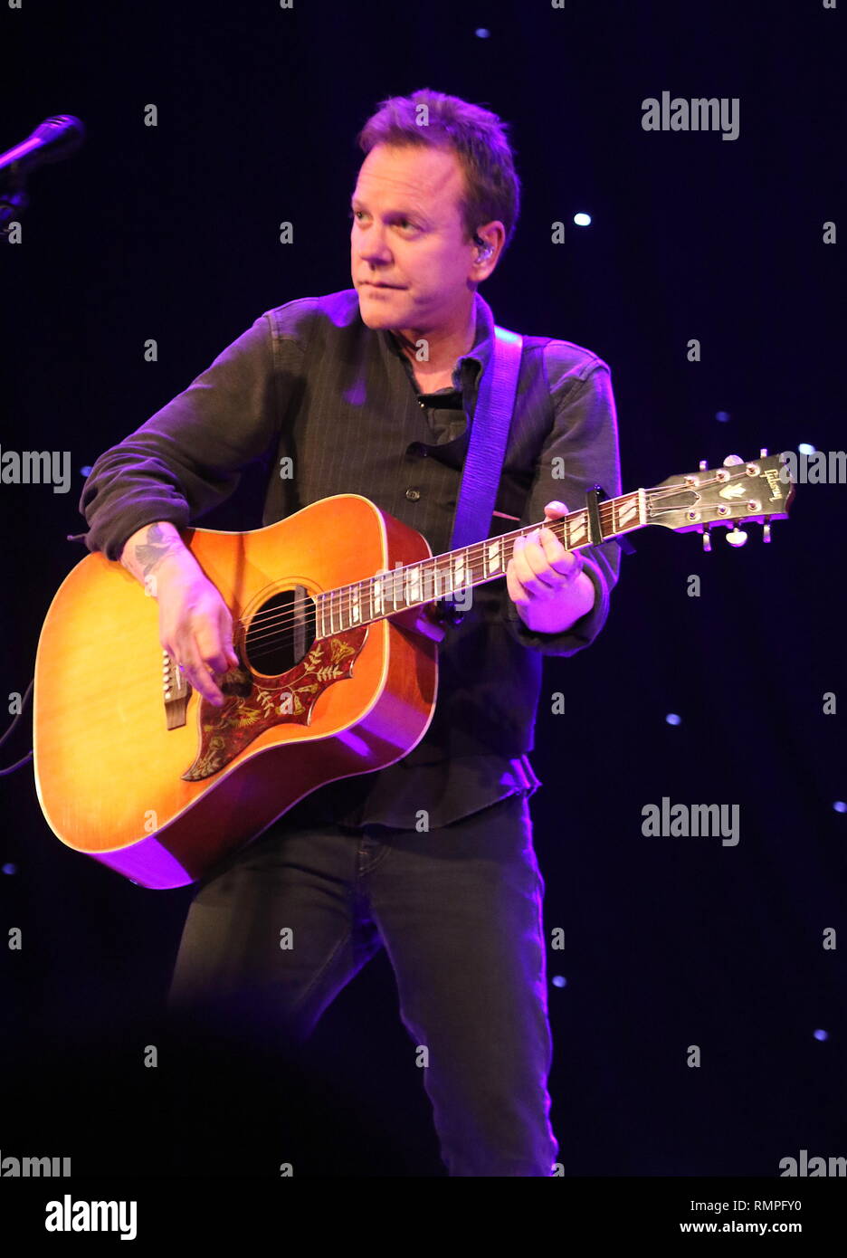 Actor, producer, director, and singer-songwriter Kiefer Sutherland is shown performing on stage during a 'live' concert appearance. Stock Photo