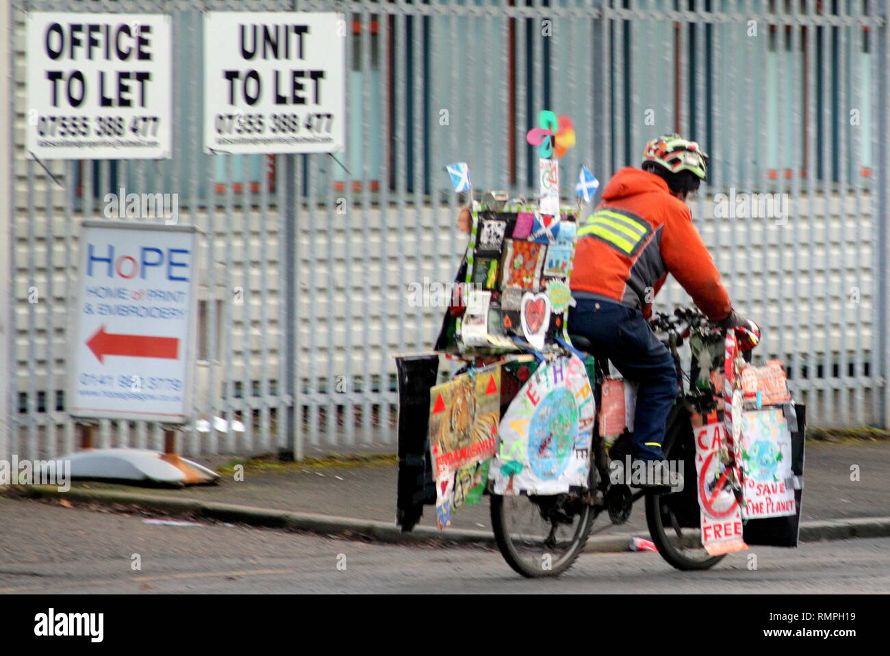 Glasgow, Scotland, UK 15th, February, 2019 Save the planet protester from the children's protest in George Square cycles home bedecked in kids protest art work maintaining integrity by not burning petrol.  Gerard Ferry/Alamy Live News Stock Photo