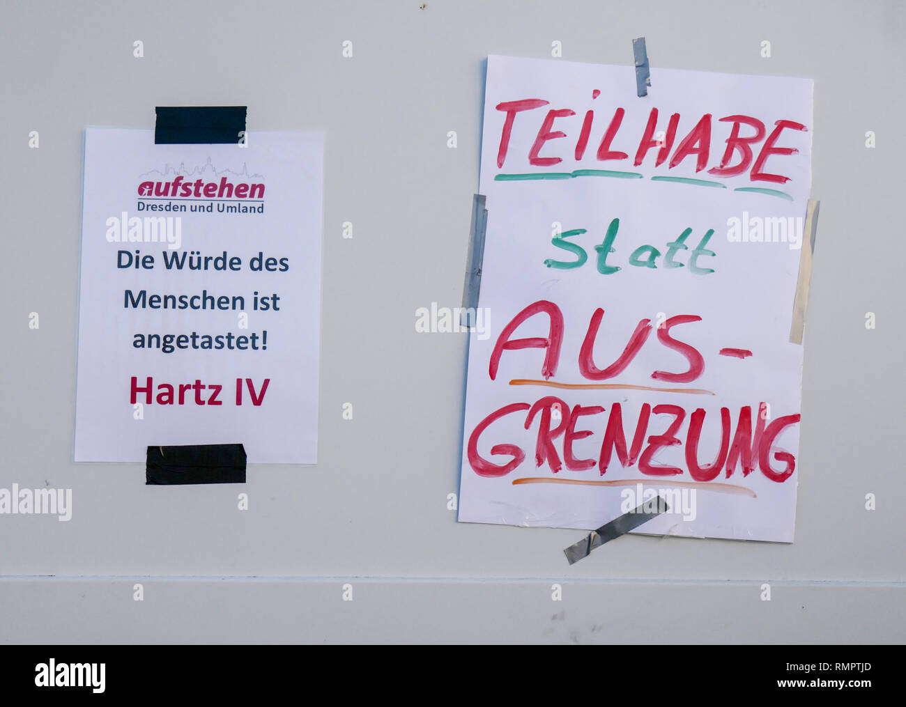 Dresden, Germany. 16th Feb, 2019. Posters with the inscription 'Die Würde des Menschen ist angetastet' Hartz IV and 'Teilhabe statt Ausgrenzung' of the collection movement 'Aufstehen - Die Sammlungsbewegung' are glued to a transporter wall at one of the nationwide demonstrations in Dresden. The demonstrators are called upon to appear in colourful warning vests, modelled on the French yellow vests. Demonstrations were announced in at least 14 German cities. Credit: Peter Endig/dpa/Alamy Live News Stock Photo