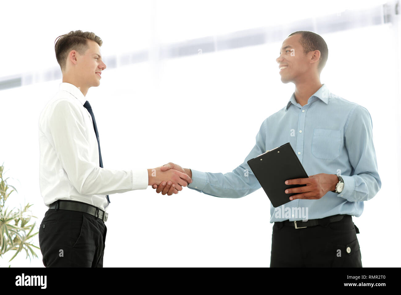 friendly business people shaking hands on blurred background Stock Photo -  Alamy