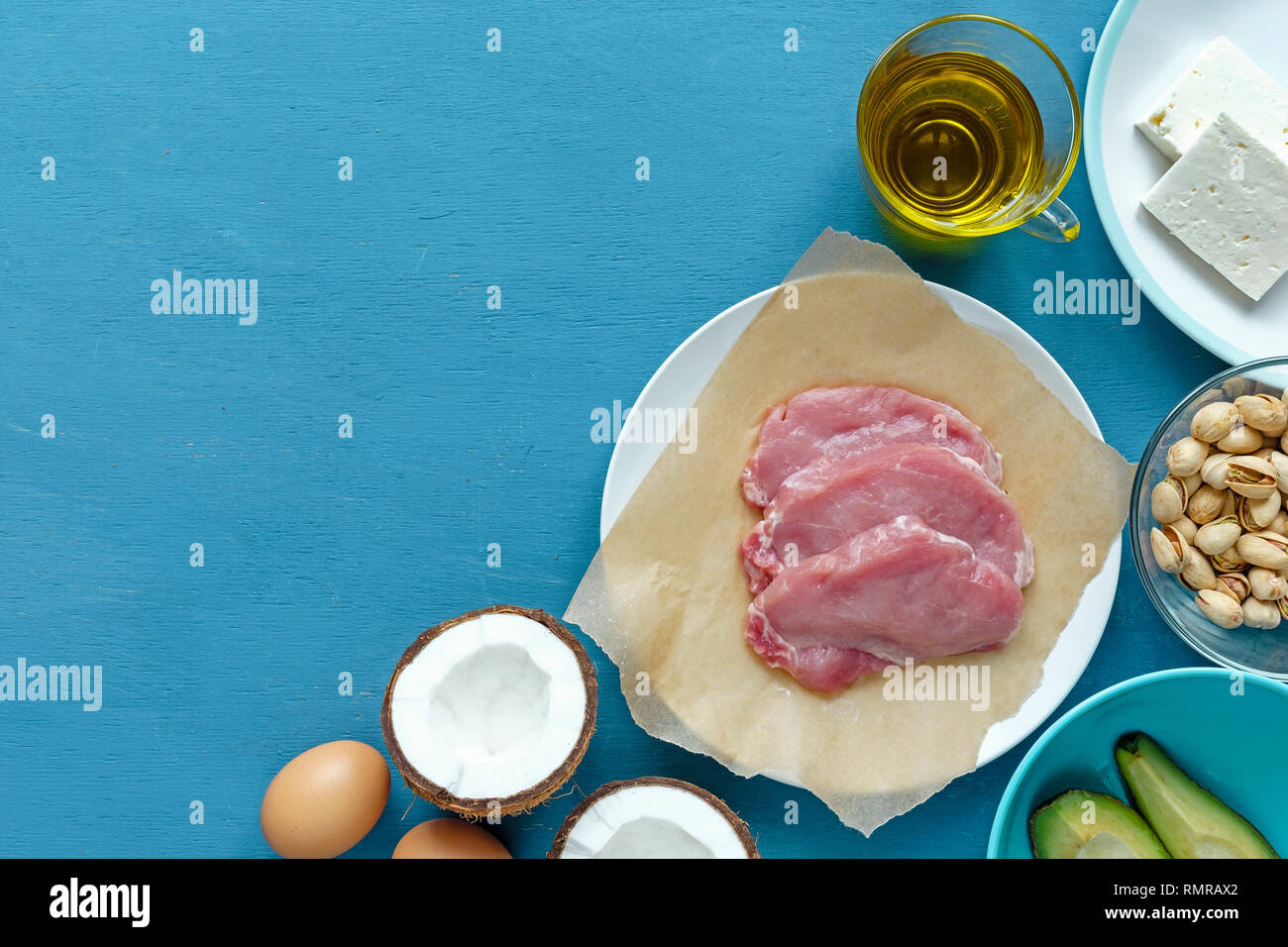 Top view layout of ingredients on kitchen table. Three raw steaks of