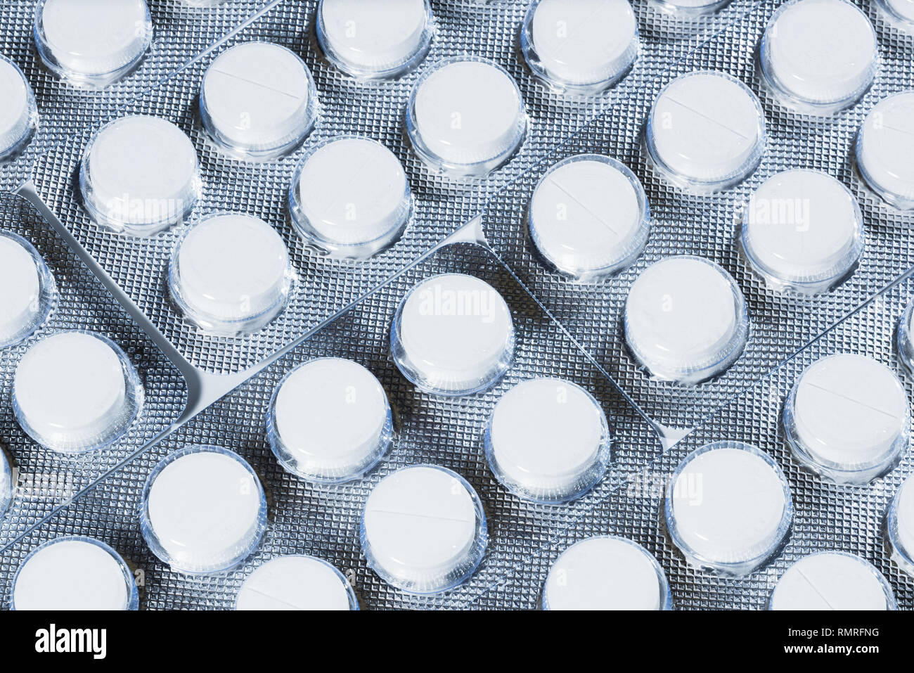 White pills in silver packaging on a white background. Stock Photo