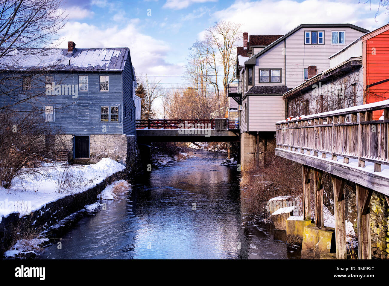 Old buildings lining the williams river running through the village of