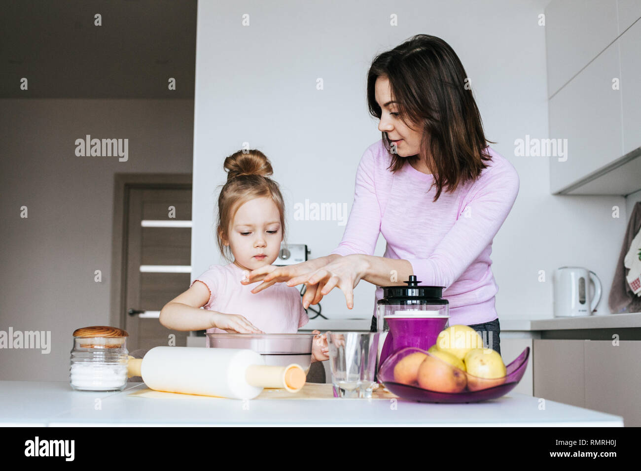 Portrait Of Adorable Little Girl And Her Mother Cooking Together Stock Photo