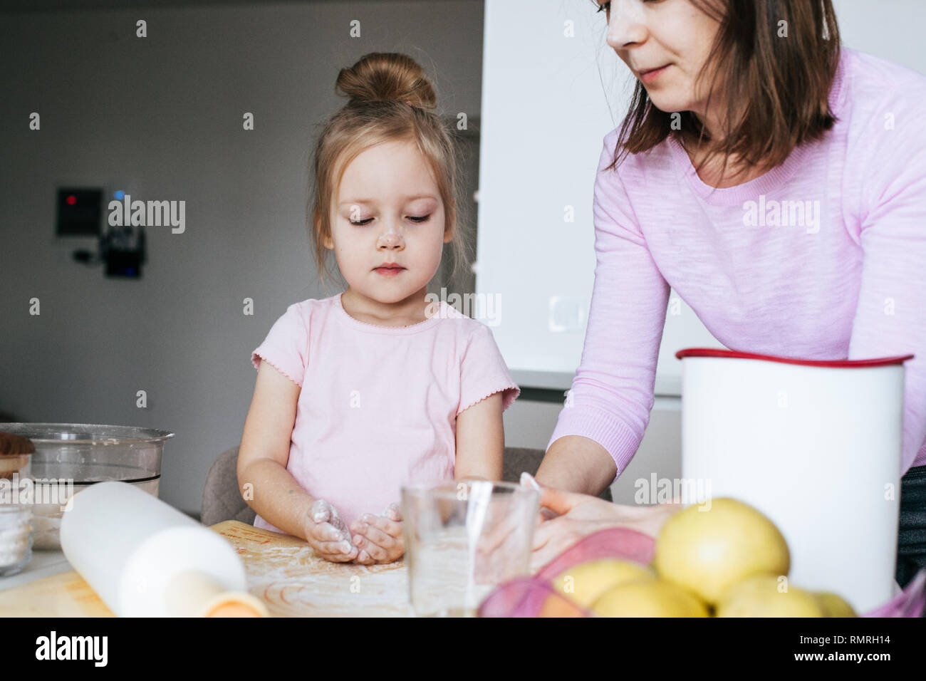 Mother teaching young daughter how to make cookies Stock Photo