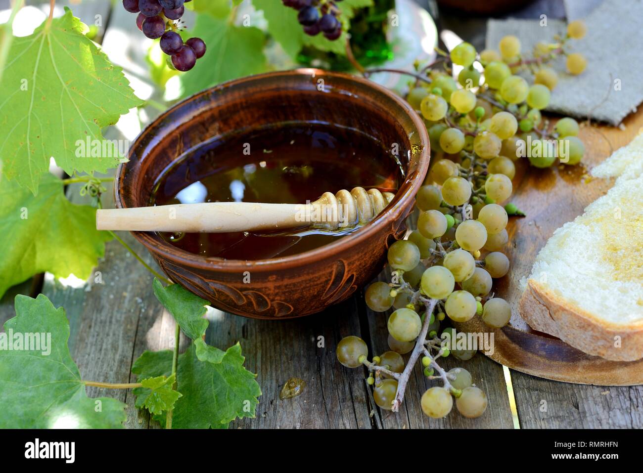 Still life with honey, grapes and white bread Stock Photo