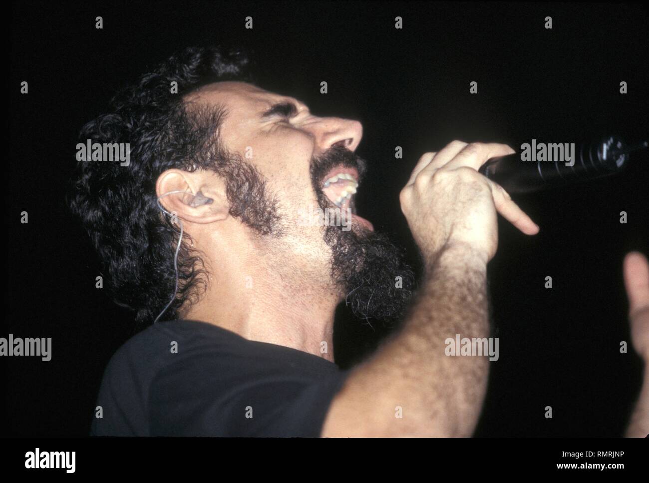 Singer Serj Tankian of the hard rock band System of a Down is shown performing on stage during 'live' concert appearance. Stock Photo