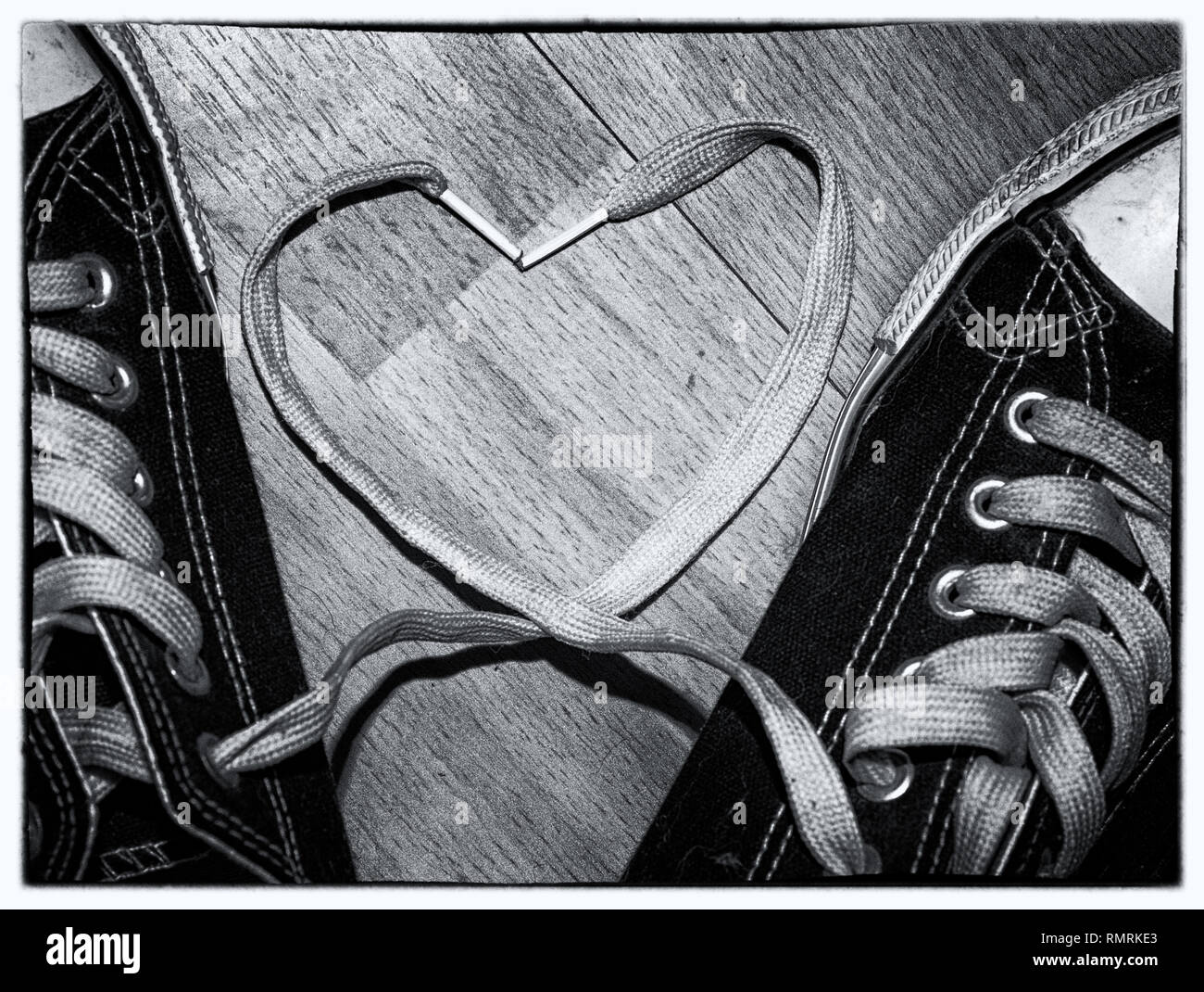 black and white image of converse trainers shoes with the laces making a heart shape Stock Photo