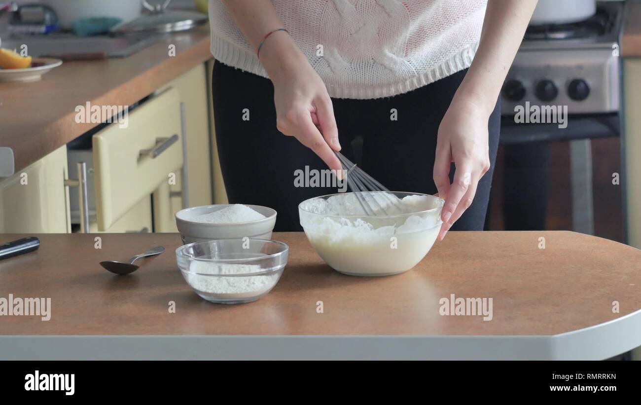 whipped egg yolks with sugar in a glass bowl Beaten egg white being mixed with egg yolk cream